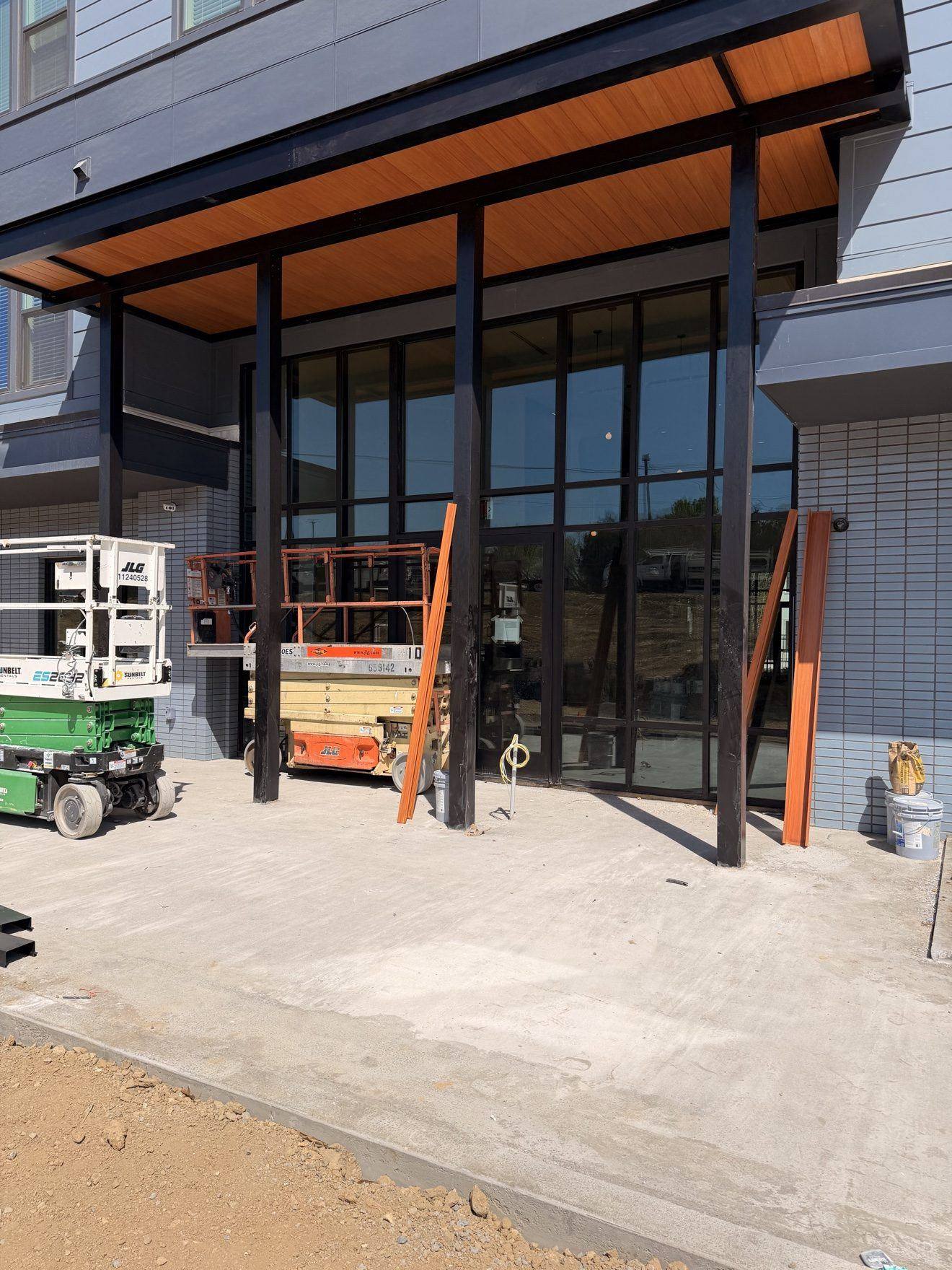 Crew working on a storefront entrance from lifts