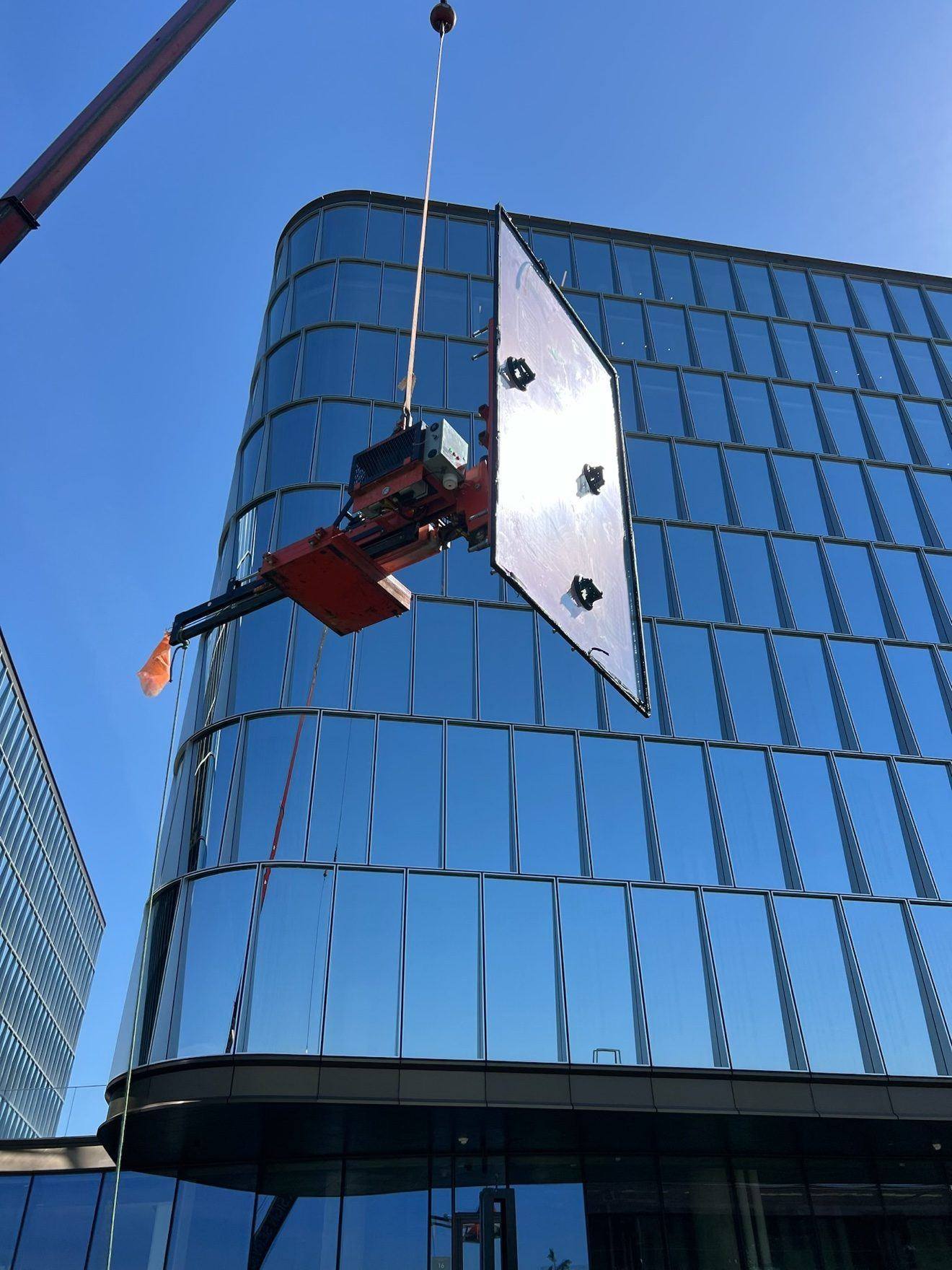 Panel setting by crane — glass panel on a curved building