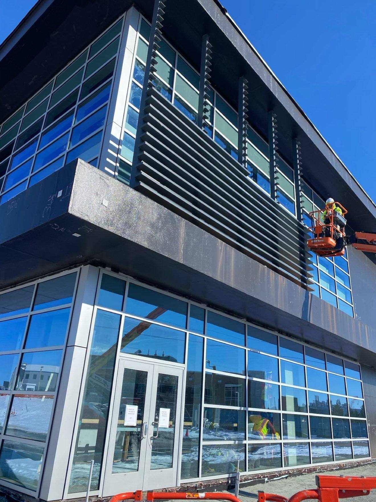 Storefront with louvers — worker on a lift